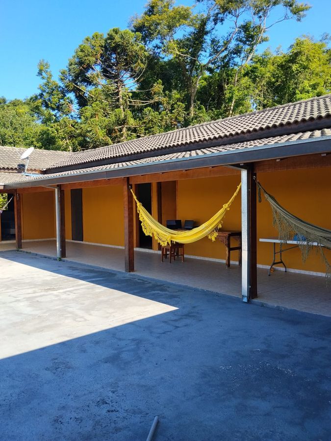 Corredor externo da chácara Recanto dos Canários com área verde — chácara de temporada em Paraibuna