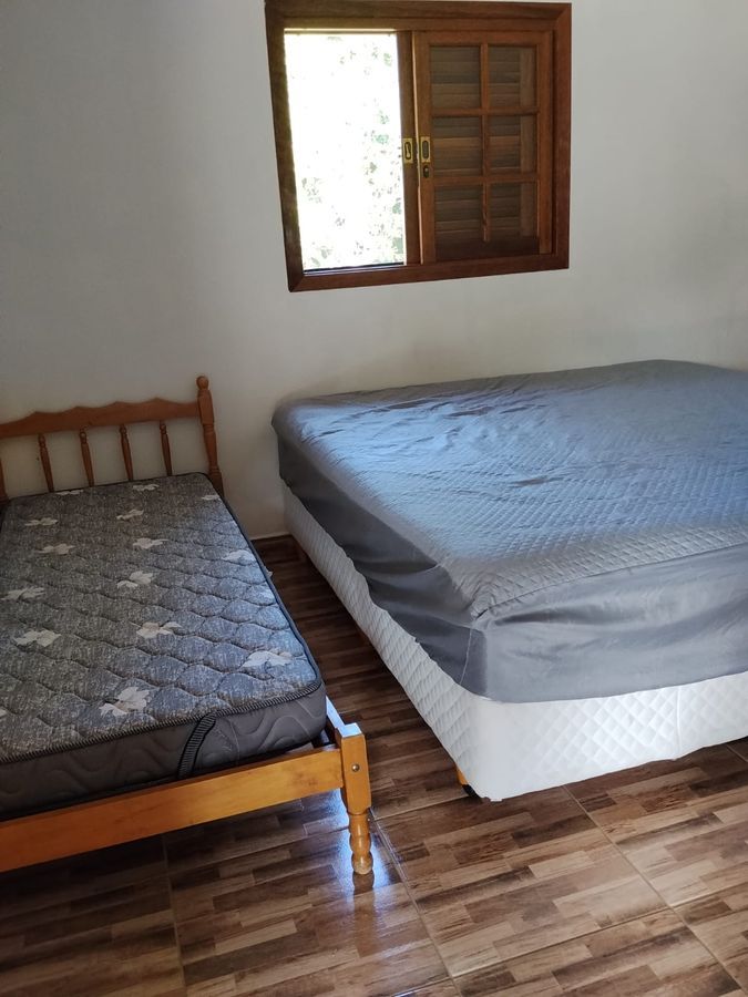Suíte 1 do Recanto dos Canários — quarto confortável com cama de casal em chácara de temporada, Paraibuna SP